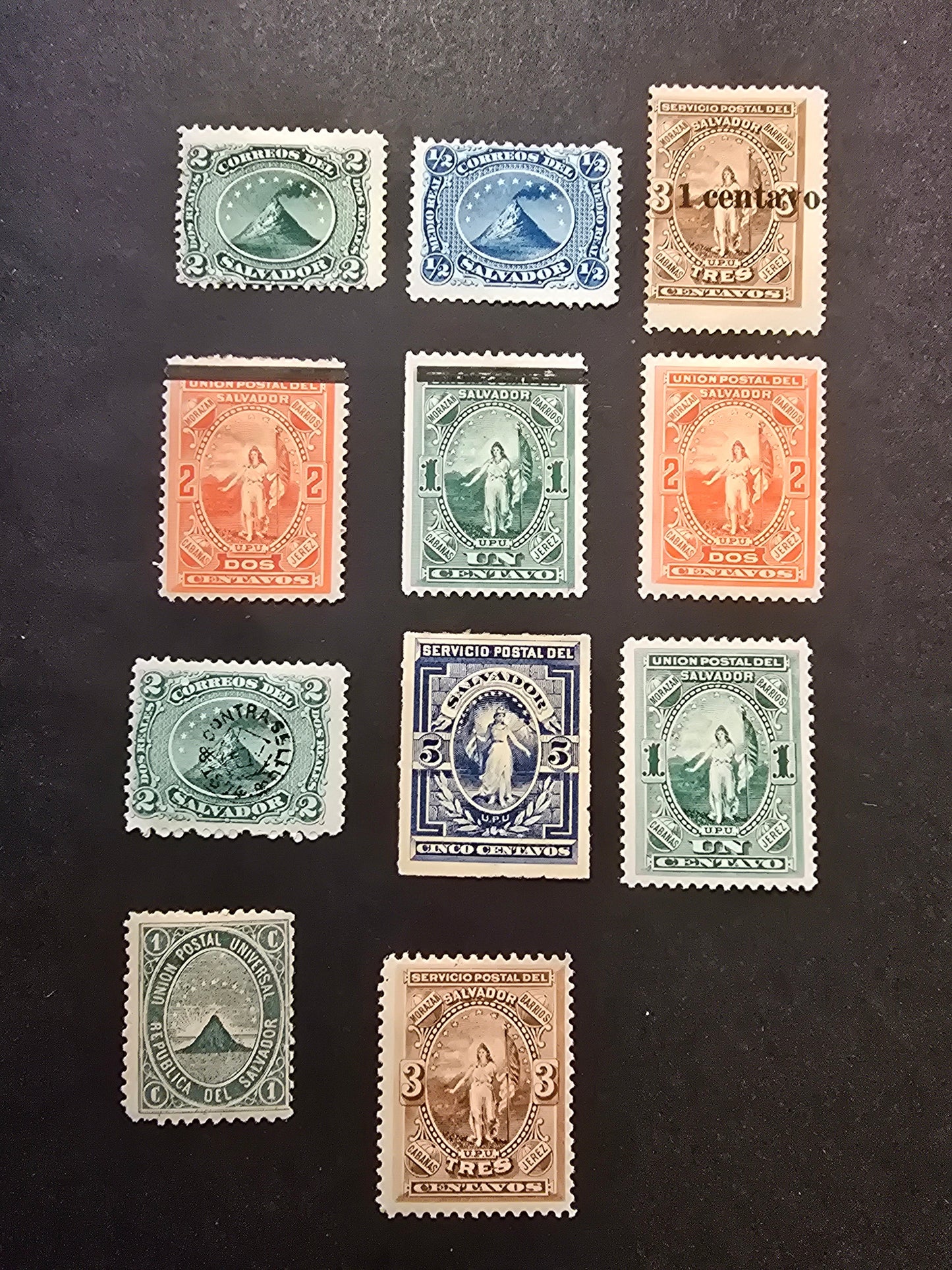 Lot 139 El Salvador SC#1a, 3a, 11, 13, 18, 20-25 1/2r - 1c on 3c Blue - Brown Volcano at Sain Miguel - Overprints, 1873-1889 Volcano - Surcharge Issues, 11 FOG Singles