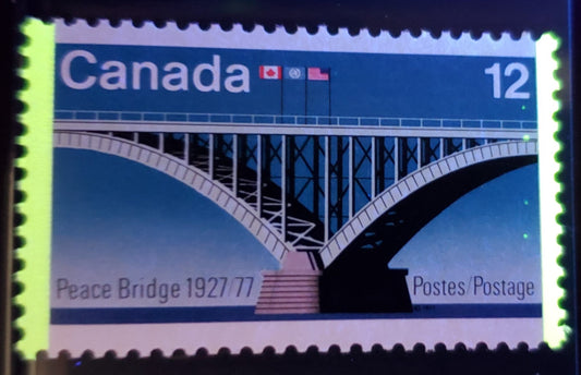 Lot 458 Canada #737iii 12c Multicolored Peace Bridge, 1977 Peace Bridge Issue, A VFNH Single On LF3-fl/F5-fl Paper With Taggant Spots Down Right Side Of Stamp